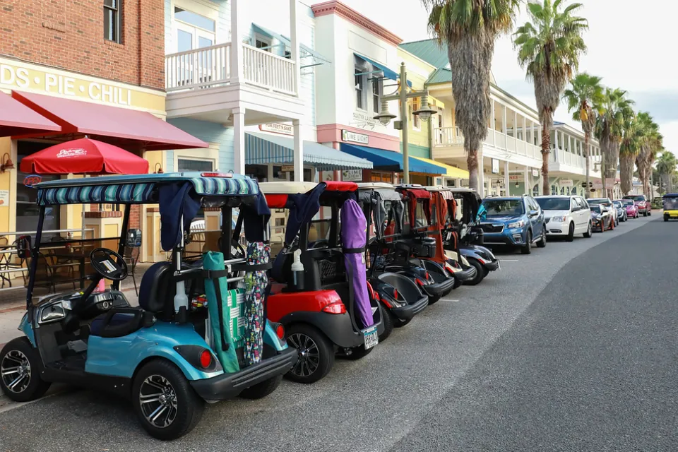 Line of colorful golf carts parked outside restaurant in The Villages, Florida